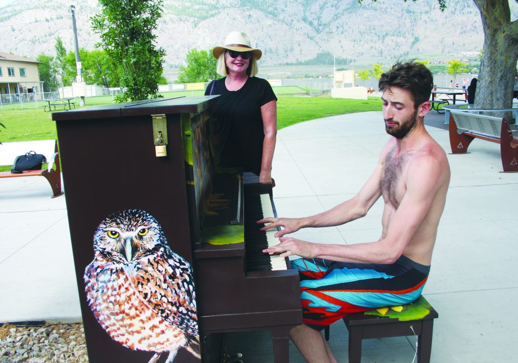 Janis St. Louis, the founder of the Piano in the Park program, looked on while Tristan Brunet-Dupont, 22, of Montreal, played only minutes after the piano was installed in Gyro Park in early June. An official opening ceremony for the Piano in the program was held the following Sunday where Kayla Turnbull, whose family donated the piano, was once of the first to play. (Keith Lacey photo)