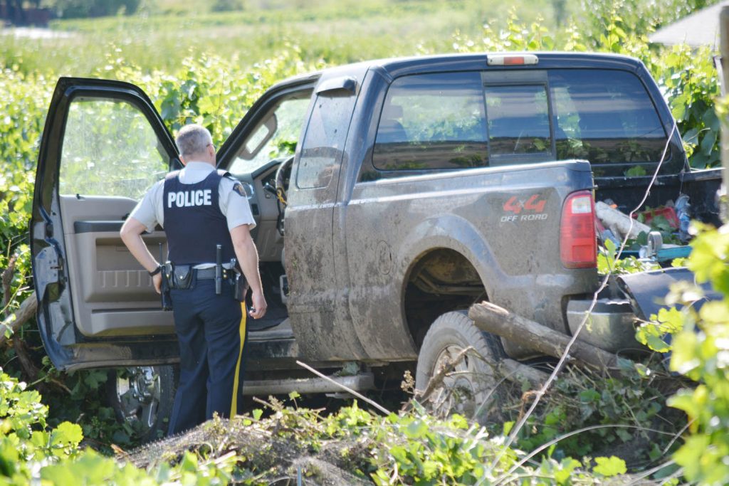 Corporal Brian Evans investigates the truck that crashed into the orchard in July. The driver, Jason Poulin, has been sentenced to two years in jail. (Lyonel Doherty photo)