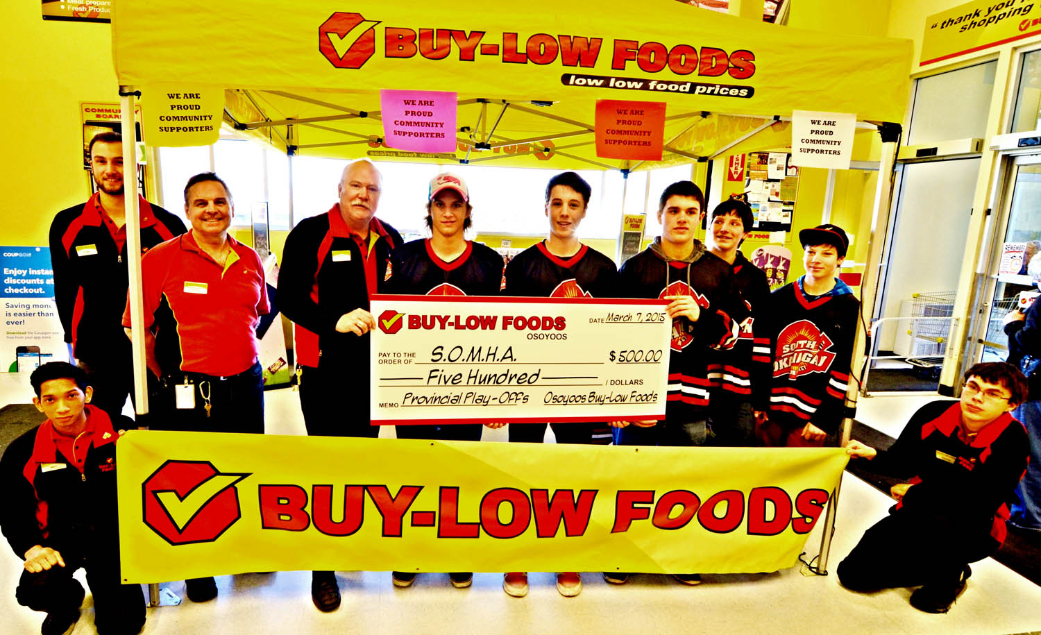 Buy-Low store manager Brian Fry (fourth from left) hands over another $500 cheque to the South Okanagan Minor Hockey Association (SOMHA). Other Buy-Low staff on hand include Robin Malcolm (far left standing), assistant manager Patrick Riley (second from left standing), Matt Alba (far left kneeling) and and Brennan Sutcliffe (far right kneeling). (Photo supplied)