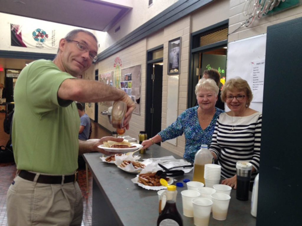 Both grocery stores in Osoyoos - Buy-Low Foods and AG Foods - donated huge amounts of food so students at Osoyoos Secondary School could hold a special pancake breakfast last Wednesday. Above, YouLearn principal Glen Heinrichs fills a plate of pancakes that were prepared by school secretaries Kathy Heibert and Donna Mikulecky. (Sharlene Fernandes photo)
