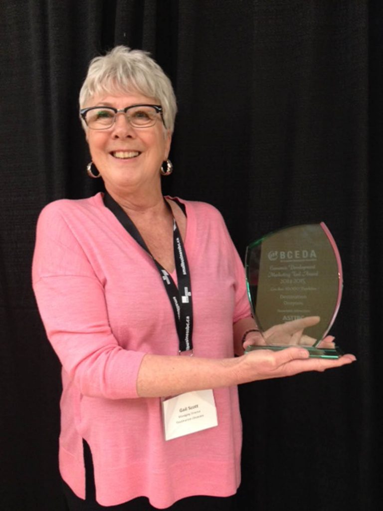 Gail Scott, the managing director of Destination Osoyoos, shows off the Marketing Collateral Award given out at the recent B.C. Economic Development Association awards in Richmond. Destination Osoyoos was recognized for publishing its successful snowbird guide. (Photo supplied)