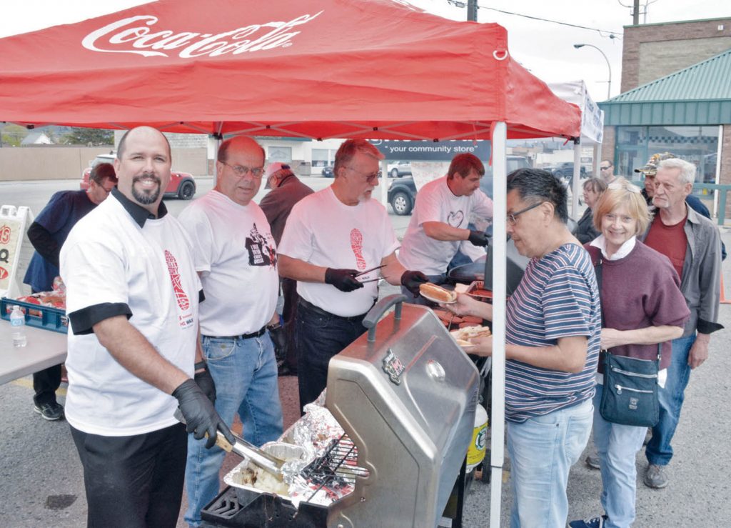 Osoyoos AG Foods manager Derek Morgan, holding the tongs, and event co-ordinator Cor Vermeulen, were pictured manning the grill during the annual Multiple Sclerosis (MS) fundraising barbecue in the parking lot outside the local grocery store this past Saturday, where $1,370 was raised for the MS Society. (Dan Walton photo)