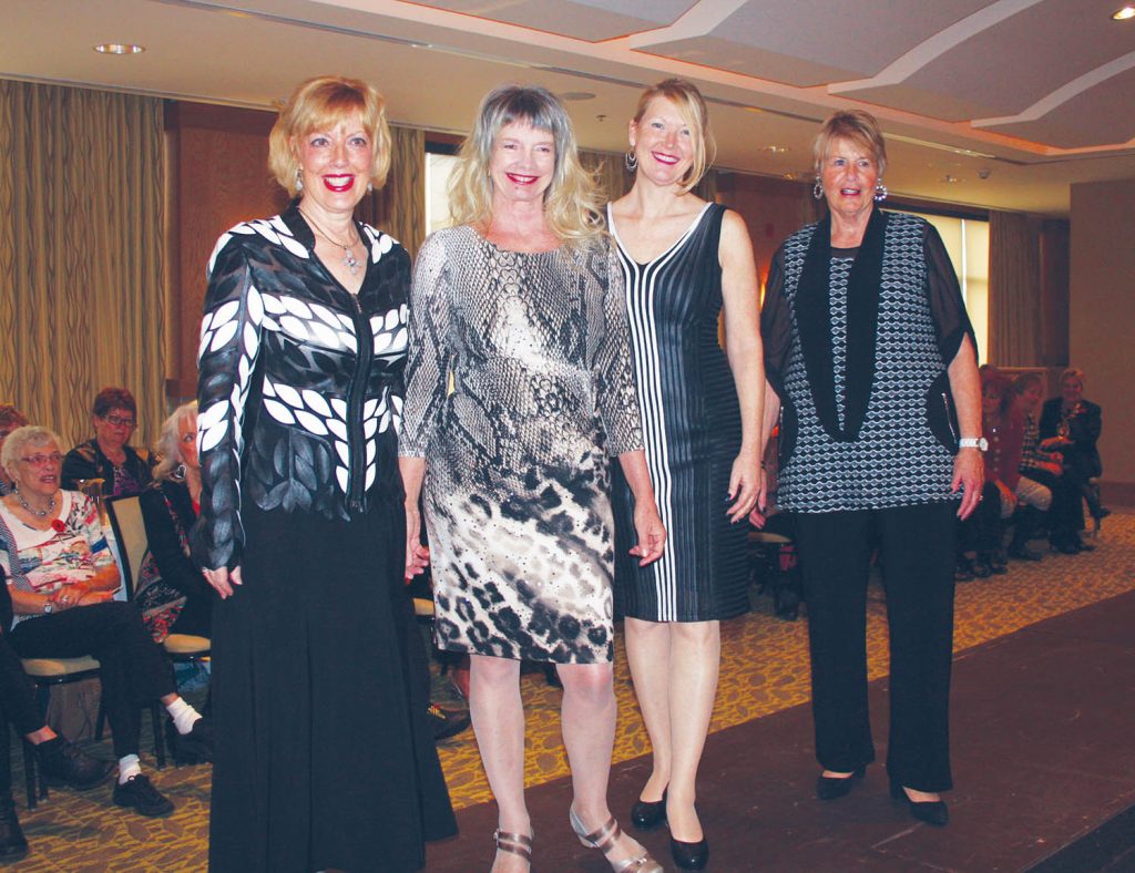 These four women showed off some of the latest fashions from Boutique de Sonia during the 2015 Osoyoos Soroptimist Club’s annual fashion show fundraiser, held this past Saturday morning in the Watermark Beach Resort. A lot of the beautiful clothing on display during the show featured dark colours, with a lot of black and blue tones on display. Posing for a photo on the runway are (from left) Johane Dumont, Karin Kilpatrick, Wendy (last name unavailable) and Joan Wilson. Proceeds from the annual fashion show go towards supporting programs and services offered by the Osoyoos Soroptimists, including a Safe Teen Program and regular donations to the Osoyoos Food Bank. (Keith Lacey photo)