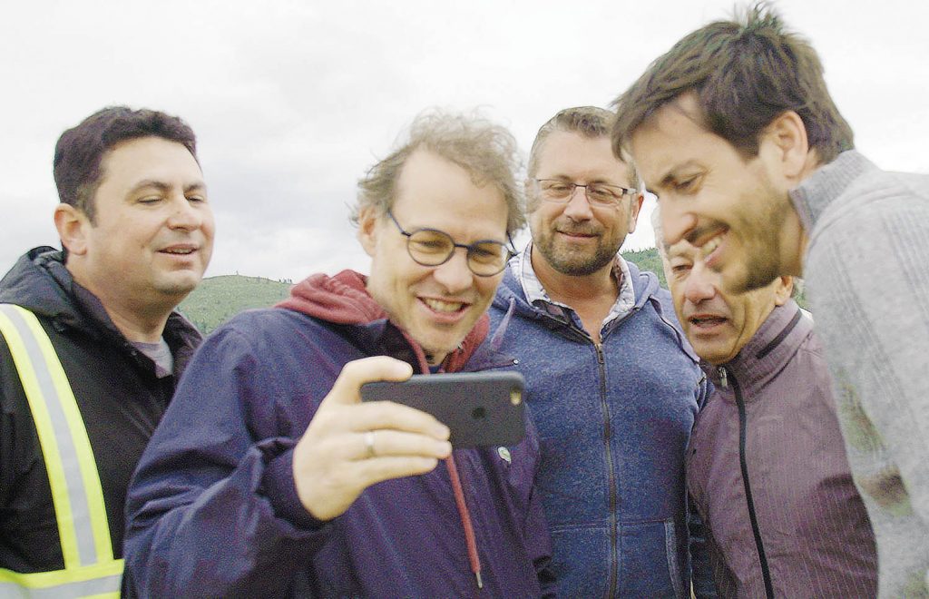 Bill Drossos (far left), the founder and president of the Area 27 motorsports facility, and Canadian race car legend Jacques Villeneuve (second from left), who designed the track and is part owner, were all smiles when several members ran test laps after the facility officially opened for business several weeks ago. A new Telus TV series called The Drivers’ Dream focuses on Area 27 from concept and design through construction and the recent opening. The six-part series will be available to all Telus Optik viewers and will also be shown on YouTube. Kenton Gilchrist from Osoyoos is the producer of the series. (Photo Supplied).