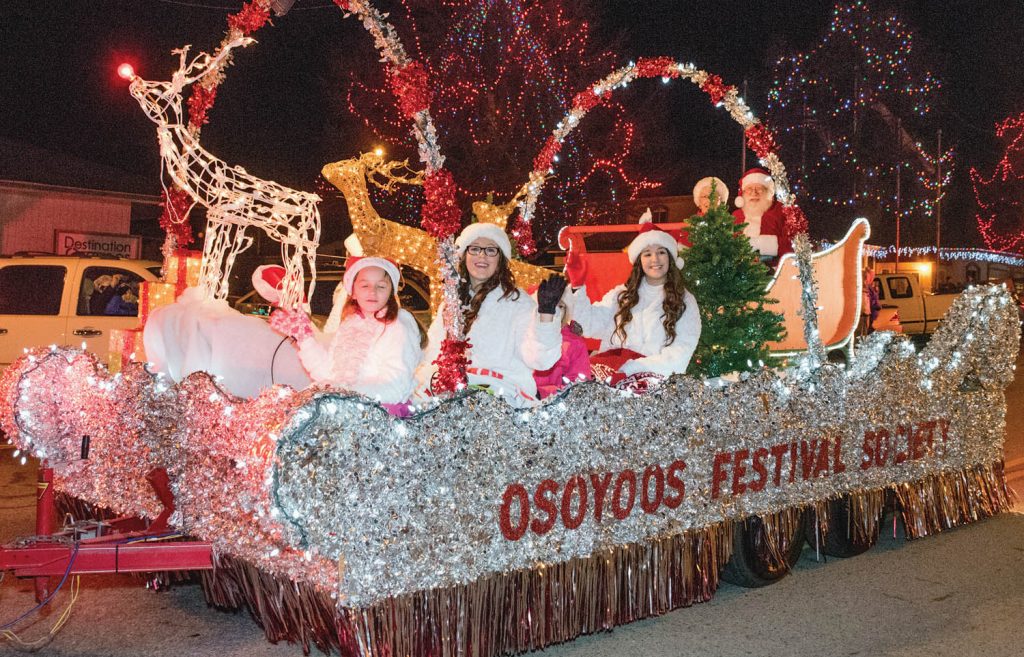 The Osoyoos Festival Society float in last year’s parade featured members of the Osoyoos Royalty, their Little Buddies and Santa and Mrs. Claus. From left are Little Buddy Kaylie Lino, Princess Bailey Toepfer and Princess Tianna Morgan. Little Buddy Jordan Kazakoff is behind Toepfer and isn’t visible in this photo. Behind are Santa and Mrs. Claus, Mike and Margaret de Salaberry. This year’s parade takes place next Friday evening on Main Street. (Richard McGuire Photo).