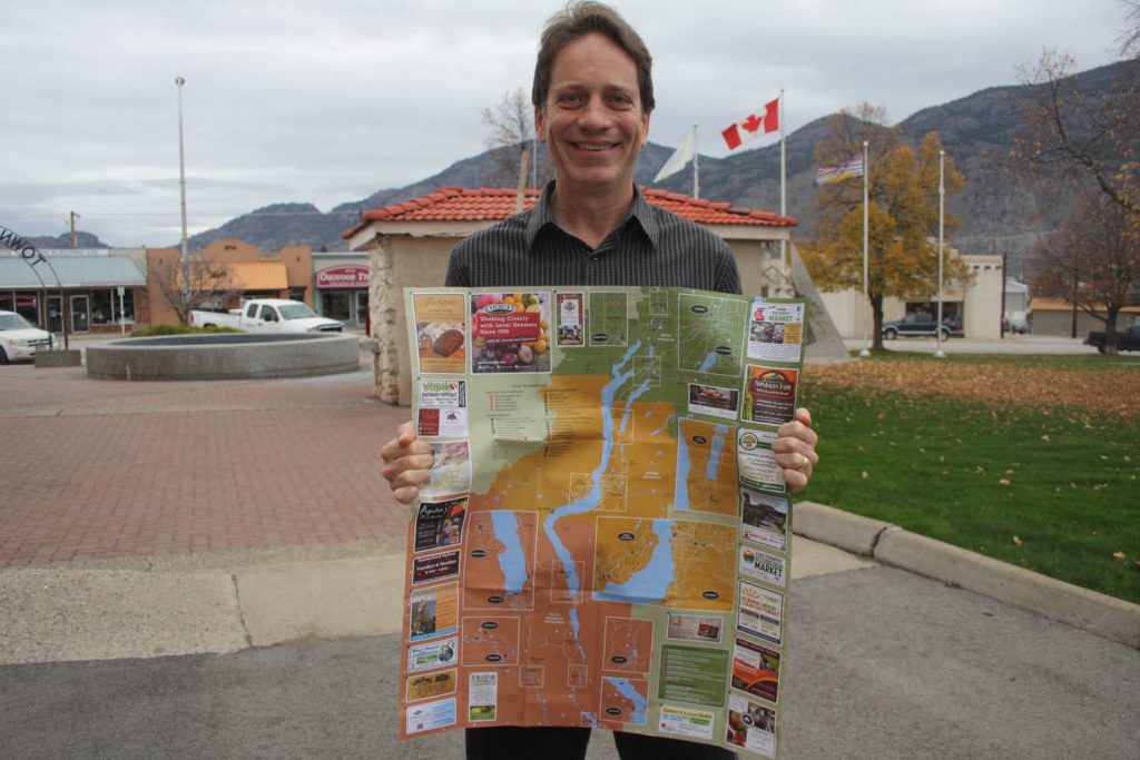 Shayne Wright, co-ordinator of the Buy Local BC Initiative, shows off the latest Buy Local! Buy Fresh! map that lists farmers and food businesses across the South Okanagan, including several here in Osoyoos. Wright made a presentation to Town of Osoyoos council on Monday detailing how the campaign and success of the maps continues to grow. A new map for farmers and food businesses in the Thompson and Shuswap regions was produced this past summer. (Keith Lacey photo)