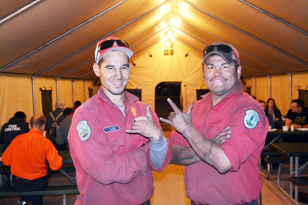 Dustin Ned (left) and Ray James stand in front of the cafeteria tent at the Testalinden Creek fire camp after another long day this past Sunday battling the stubborn blaze. (Trevor Nichols photo)