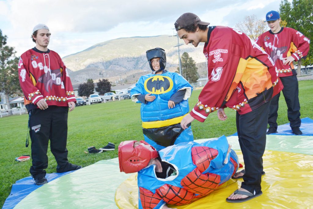 Members of the Osoyoos Coyotes volunteered to help out at the Tuc-el-Nuit Elementary School barbecue on Tuesday, Oct. 4. Here, they referee during the little sumo wrestling match. (Lyonel Doherty photo)