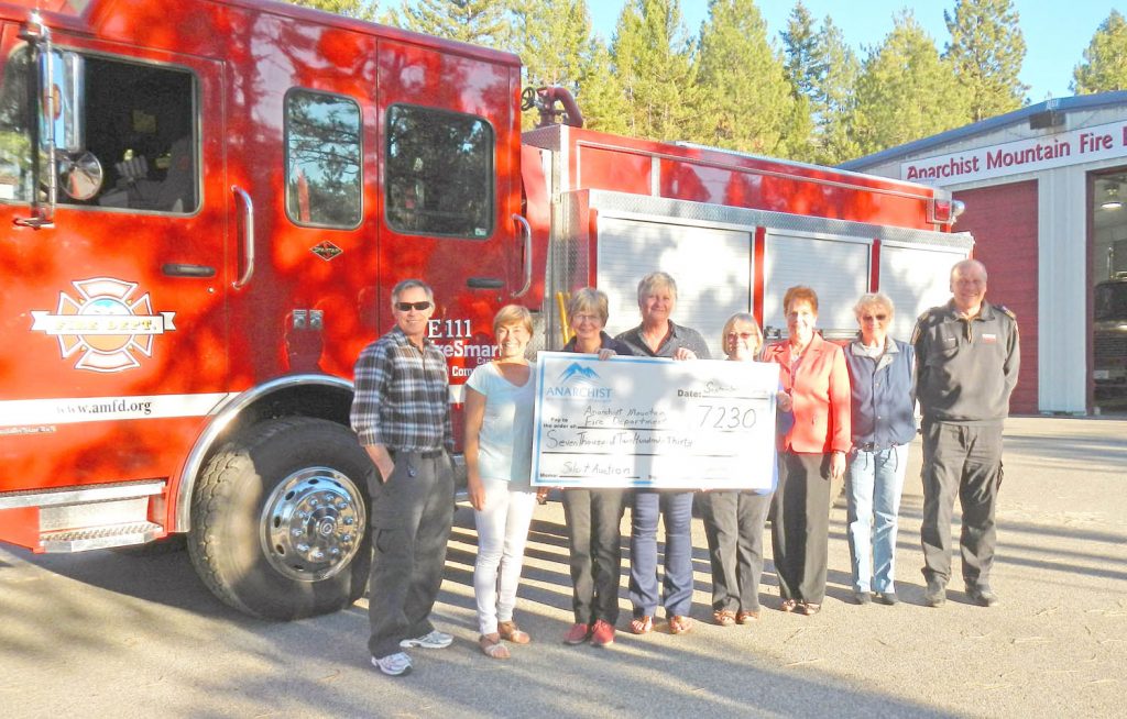 The Anarchist Mountain Community Society (AMCS) recently donated the funds raised from its fundraising efforts to their volunteer fire department.  Pictured in this photo are:  Wayne Kelley, Wendy Barlow and Candy Anders of the silent auction committee, Patti Brazeau and Teresa Marty of the AMCS,  Marie Therren and Anne Polischuk representing all the donors including DORCAS-United Church Thrift Shop, and Urs Grob, fire chief of Anarchist Mountain Fire Department, recipient of the cheque. (Photo supplied)