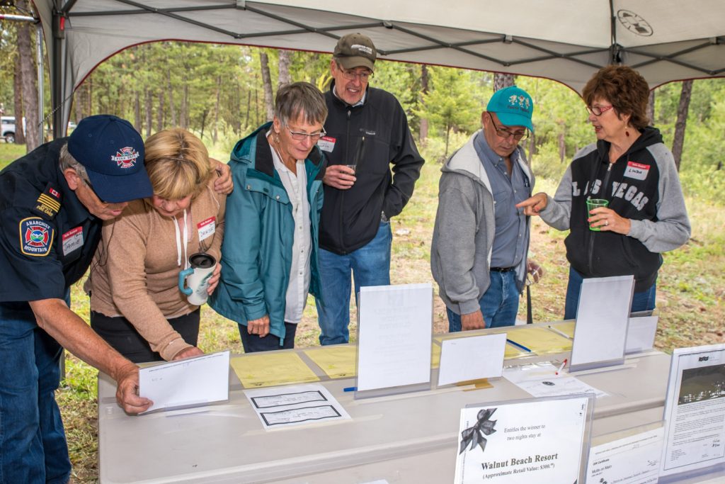 Members of the Anarchist Mountain community bid on silent auction items donated by businesses at the annual community barbecue on Saturday. The event helps to raise money for the Anarchist Mountain Fire Department. (Richard McGuire photo)
