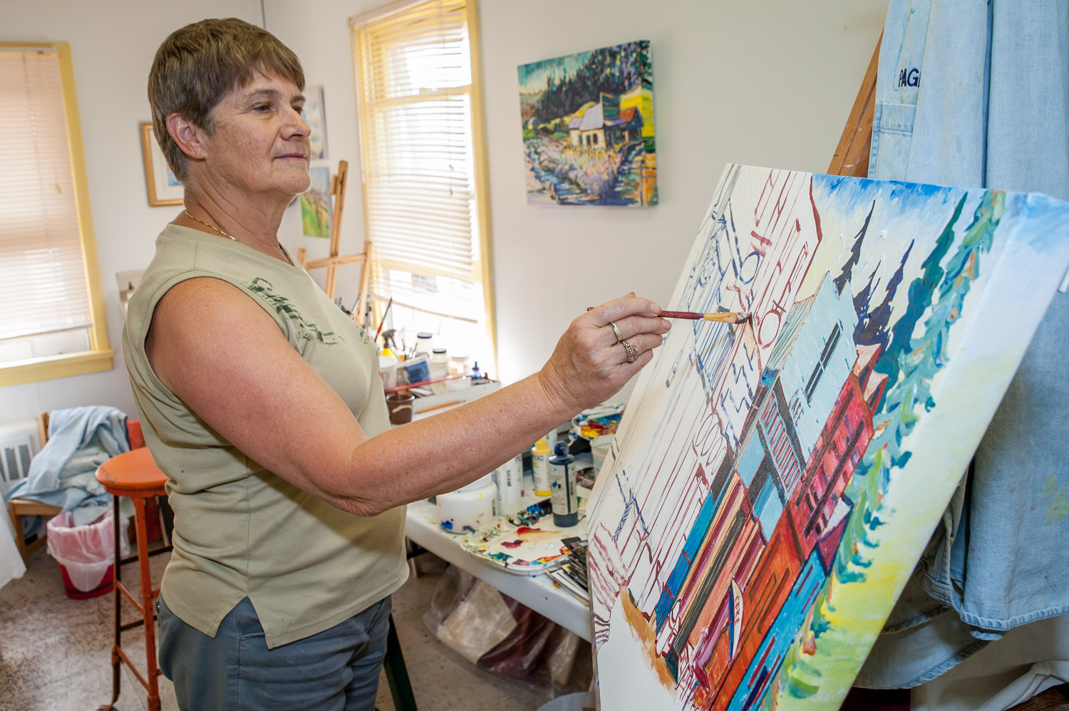 Artist Sandy Albo, of Artists on Main, works on a painting of a historic street scene in the group's studio above the art gallery. She is one of about 30 local painters in the group whose work will be featured in a new exhibition at Osoyoos Art Gallery that starts this weekend. (Richard McGuire photo)