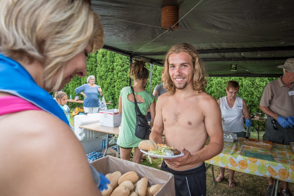 Francis Mongeau, from Ste-Julie near Montreal, is happy as Val Neufeldt from Abbotsford gives him a bun to go with his steak. (Richard McGuire photo)
