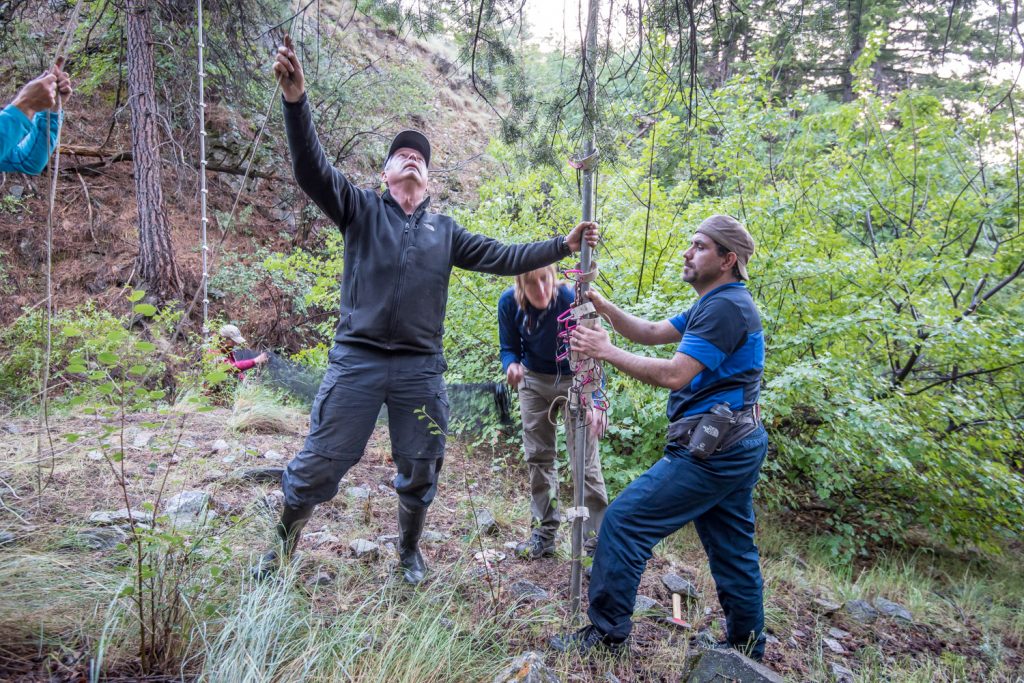 Doug Burles (left) and Hossein Zohoori check a guy rope and steady a pole while Leigh Anne Isaac (behind) brings up a net. (Richard McGuire photo)