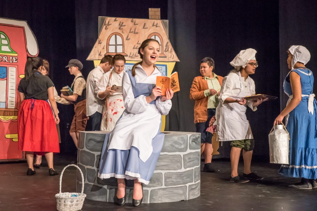 Hannah Shiels in the role of the bookish Belle reads (and sings) as she is surrounded by French villagers in the Osoyoos Secondary School drama club’s production of Beauty and the Beast. The musical will be staged Friday and Saturday at 7 p.m. and at a Sunday matinee at 3 p.m. (Richard McGuire photo)