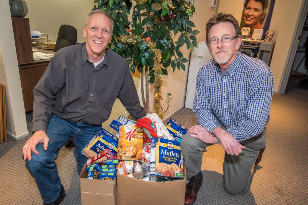 Since the start of the Christmas season, Beltone has been collecting items from customers for the Osoyoos Food Bank. Last week owner Bill Fowlie (right) turned over the items to a grateful Pastor Phil Johnson of Osoyoos Baptist Church, which operates the food bank. Fowlie's wife and fellow owner Cherie couldn't be there for the picture. (Richard McGuire photo)