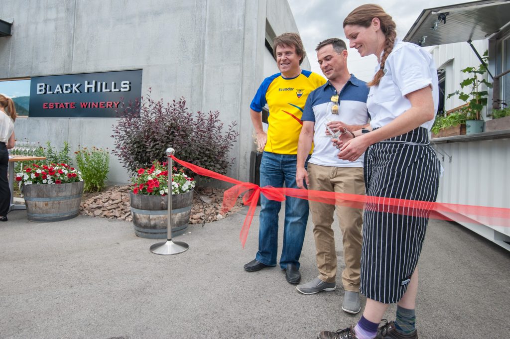 Dana Ewart, right, co-owner of Joy Road, cuts the ribbon while Black Hills President Glenn Fawcett (left) and Winemaker Graham Pierce look on. (Richard McGuire photo)