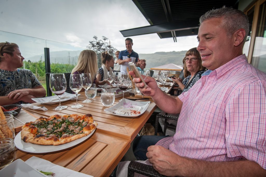 Steve Ceron, general manager and publisher of the Osoyoos Times, photographs a pizza dish on his iPhone. Ceron is a lover of good food. (Richard McGuire photo)