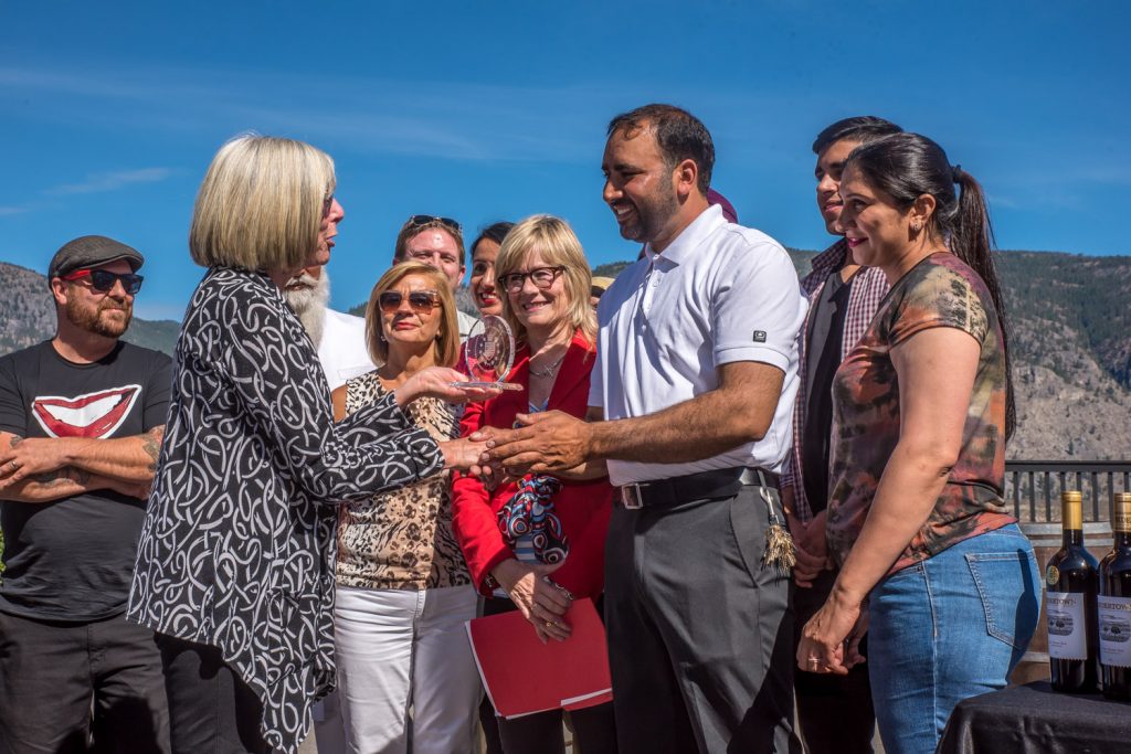 B.C. Lieutenant Governor Judith Guichon congratulates Mohan Gill, the owner of Bordertown Vineyards & Estate Winery, and members of his staff and family last Friday afternoon. Bordertown’s 2013 Living Desert Red was one of 14 awards captured by wineries in the Okanagan Valley as part of the annual Lieutenant Governor wine awards. (Richard McGuire photo)