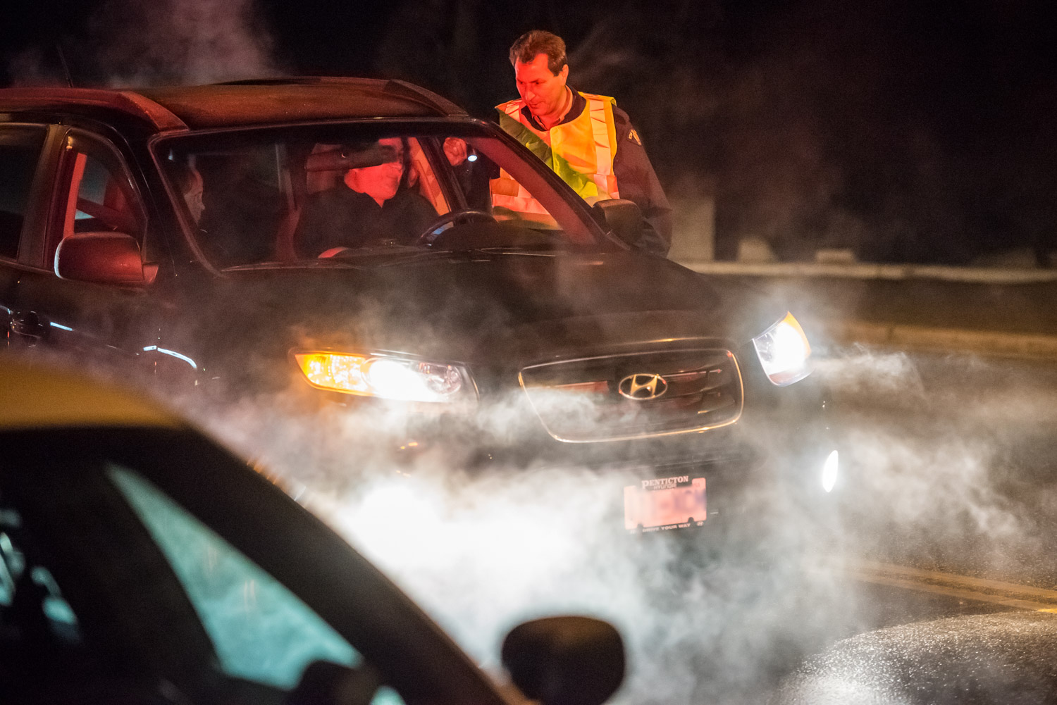 Constable Bruce Stangl speaks to a driver during a CounterAttack road check on Hwy. 3 on Saturday evening. Osoyoos RCMP were on the lookout for impaired drivers, but they didn't encounter any. (Richard McGuire photo)