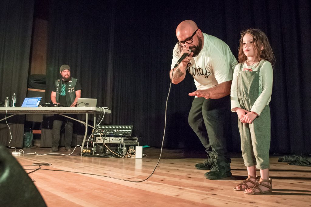 Rhode Island based rapper B. Dolan put in a surprise appearance Sunday at a free concert for students of Osoyoos Secondary School and other members of the community. Pictured here, he invited Alyra Mills, 4, onto the stage to dance. She stood at attention before performing a few twirls. In the background is DJ Jonny Williams. The event was organized by Jamie Elder of Unity Osoyoos, and was originally only going to feature Canadian hip-hop artist Transit, who is opening for Dolan's concerts on a current tour. The two were performing at JoJo's Café that evening. (Richard McGuire photo)