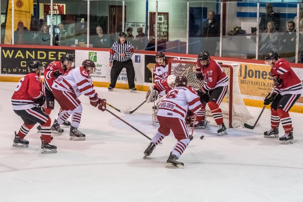 Carter Robinson (No. 16) of the Coyotes chases after a loose puck in front of the Kelowna net during a power play, but goalie Brady Lenardon and Kyle Laird (No. 25) manage to stop him. (Richard McGuire photo)