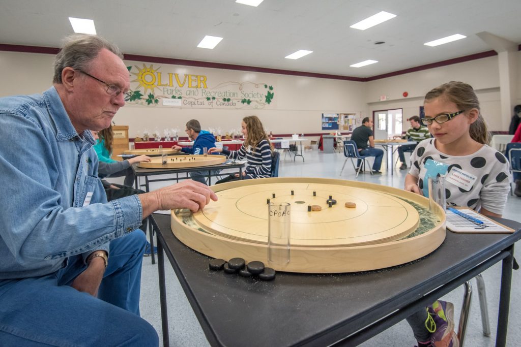 Chuck Van Dusen (left) of Oliver faced Laska Hughes of Summerland in a round of the seventh annual B.C. Crokinole Championship Tournament at the Oliver Community Centre on Saturday. (Richard McGuire photo)