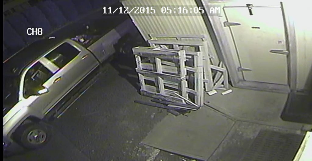 The truck pulls up next to a walk-in freezer.