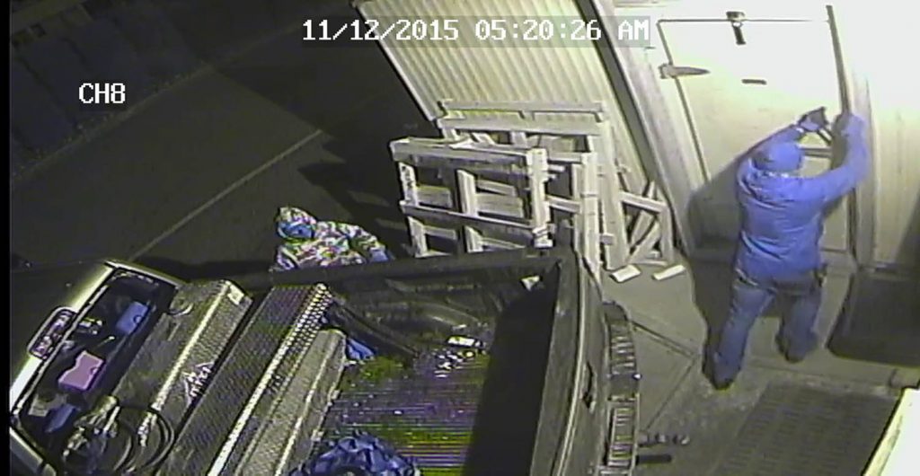 A suspect forces the door to the walk-in freezer.