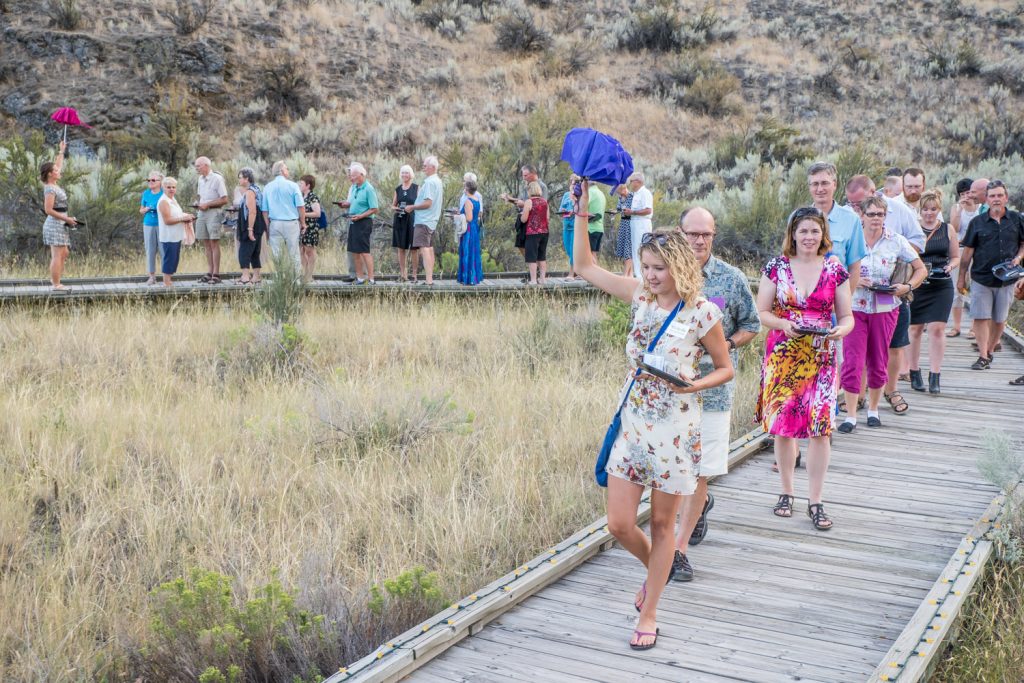 After dinner at Romancing the Desert, guests headed out onto the boardwalk for a guided tour. In the foreground, Michelle Lancaster, holds up a blue umbrella to indicate that those with blue cards should follow her. (Richard McGuire photo)