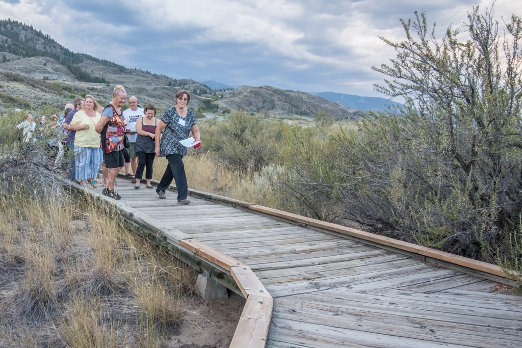 Lee McFadyen, president of the Osoyoos Desert Society, leads a group of guests on a guided tour along the boardwalk at Romancing the Desert on Saturday evening. (Richard McGuire photo)