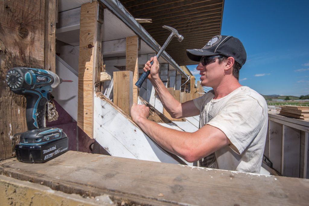 Craig Piper works to remove rotten wood from the bleachers at Desert Park. (Richard McGuire photo)