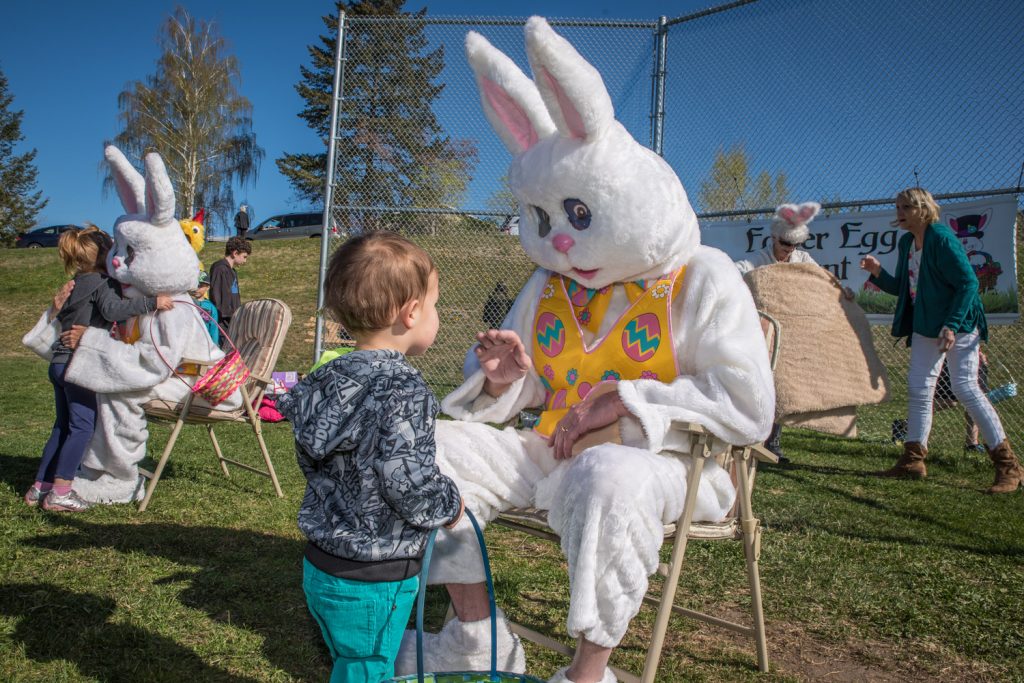 Children lined up to hug or give high-fives to two Easter Bunnies after the egg hunt. The bunnies were Ronda Jahn (left) and Ken Baker of the the Osoyoos Times. (Richard McGuire photo)