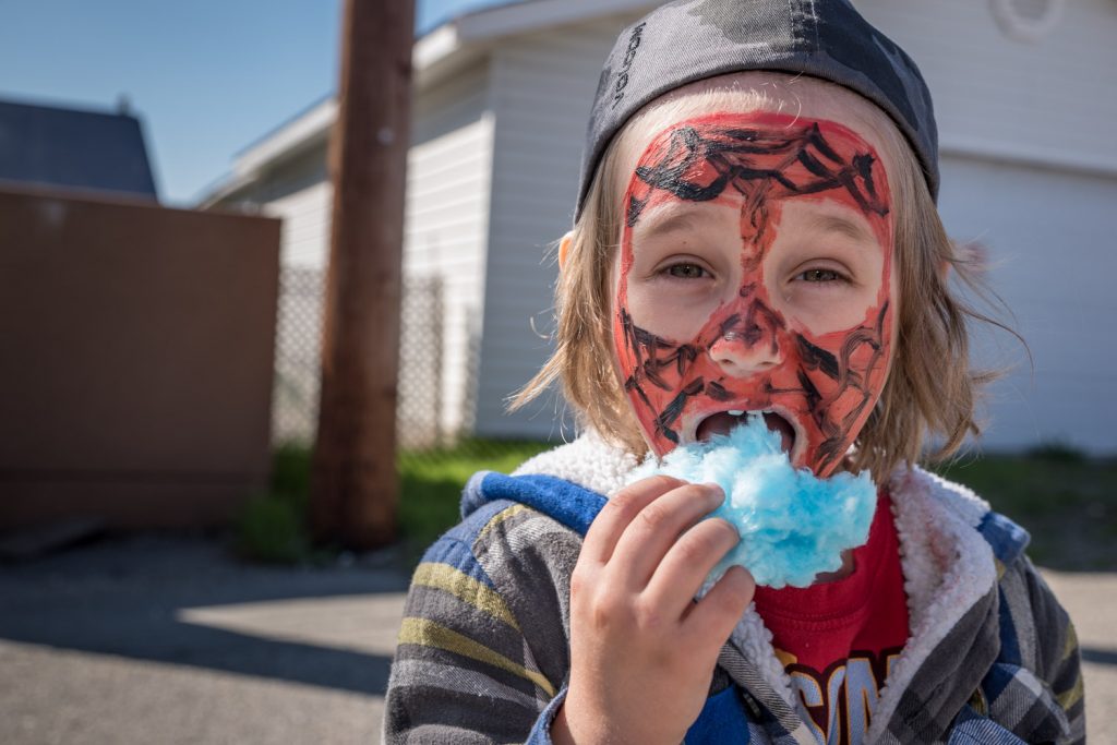 Logan Keeping, 4, of Osoyoos, enjoyed a big mouthful of candy floss after getting his face painted. (Richard McGuire photo)