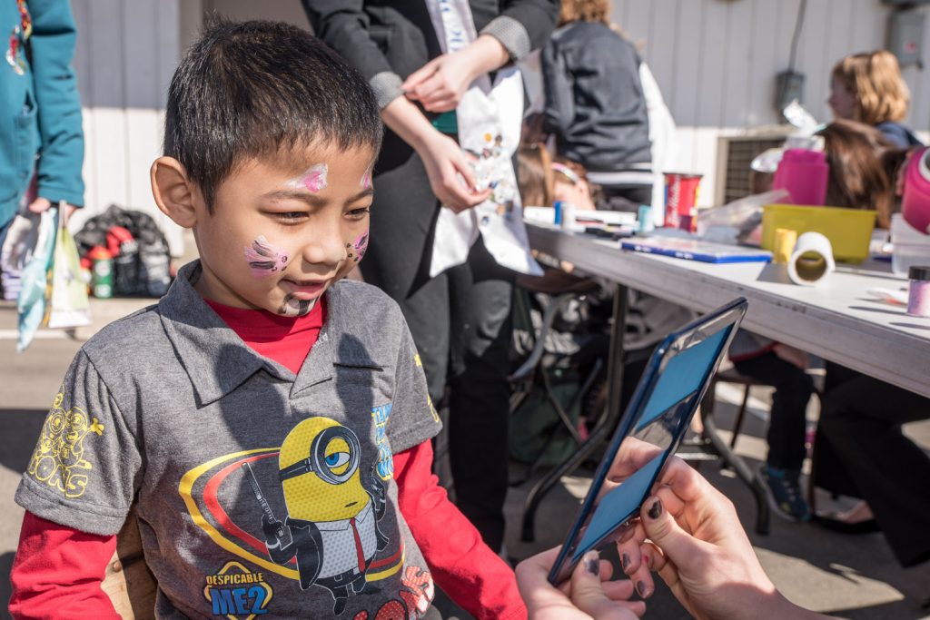 Christian Urdas, 7, of Osoyoos, takes a look in the mirror after getting his face painted by Ali Hutter, an Osoyoos Royalty princess. (Richard McGuire photo)