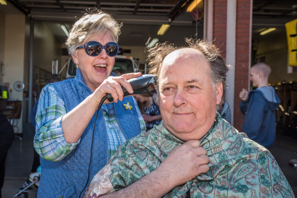 Osoyoos Mayor Sue McKortoff looks like she's enjoying taking the hair off Fire Chief Rick Jones. The firefighters were losing their hair and selling hot dogs to raise funds for cancer at Easter Eggstravaganza. Jones offered to shave McKortoff's head, but she wasn't interested. (Richard McGuire photo)