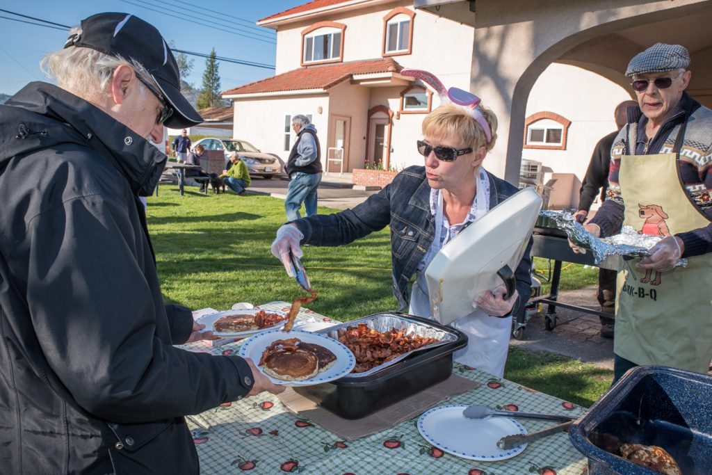 Karen Somerset serves bacon at the Rotary Pancake Breakfast that kicked off Easter Eggstravaganza. (Richard McGuire photo)
