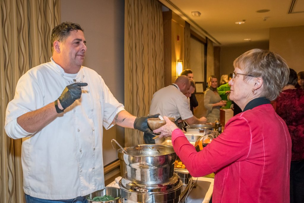 Doug Hynford, Exeutive Chef at Talons at Spirit Ridge serves his soup to Pat Wessel of Oliver at the Empty Bowls Fundraiser for Desert Sun Counselling and Resource Centre. Hynford's soup was unique -- chunky with beans -- while the other chefs chose an assortment of puréed soups. (Richard McGuire photo)