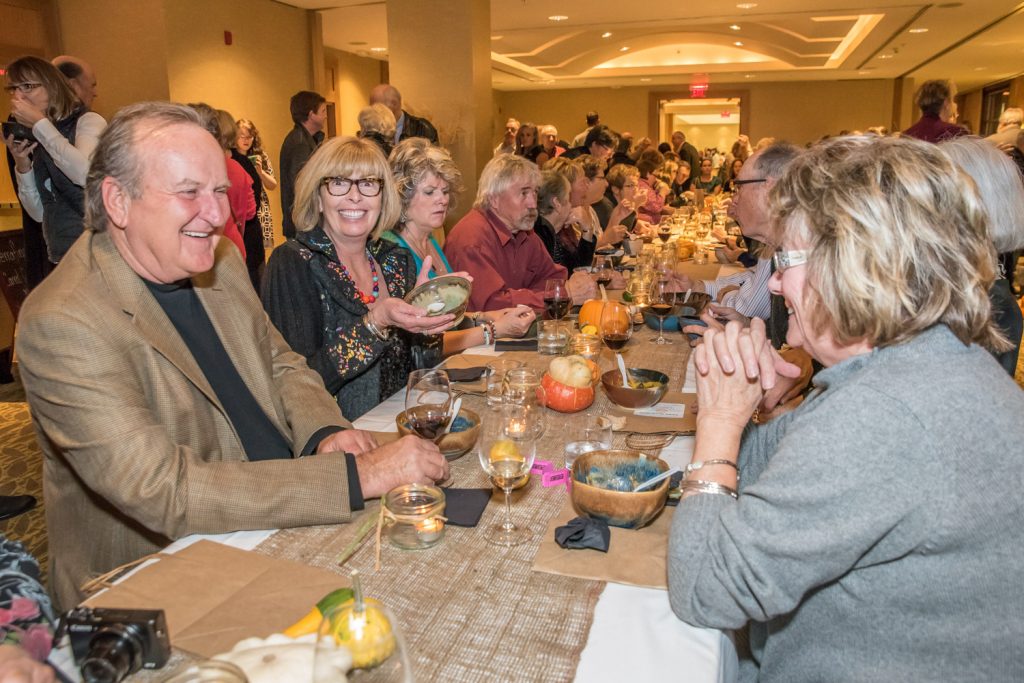 Guests take turns sitting at a long communal table during the Empty Bowls Fundraiser for Desert Sun Counselling and Resource Centre at the Watermark Beach Resort on Saturday. In the foreground former Mayor Stu Wells, his wife Martha Collins and Coun. Carol Youngberg engage in conversation as they enjoy gourmet soup and wine. (Richard McGuire photo)