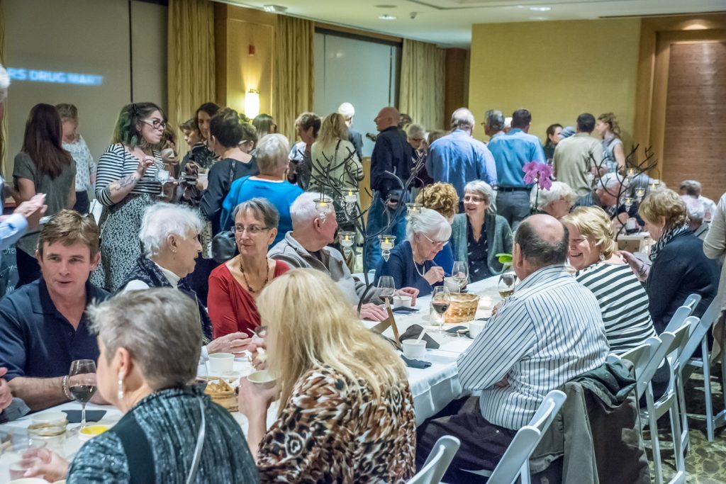 Guests eat their soups at a long communal table at Desert Sun's Empty Bowls fundraiser Friday night while others stand in line to sample soups, ice cream or buy wine. (Richard McGuire photo)