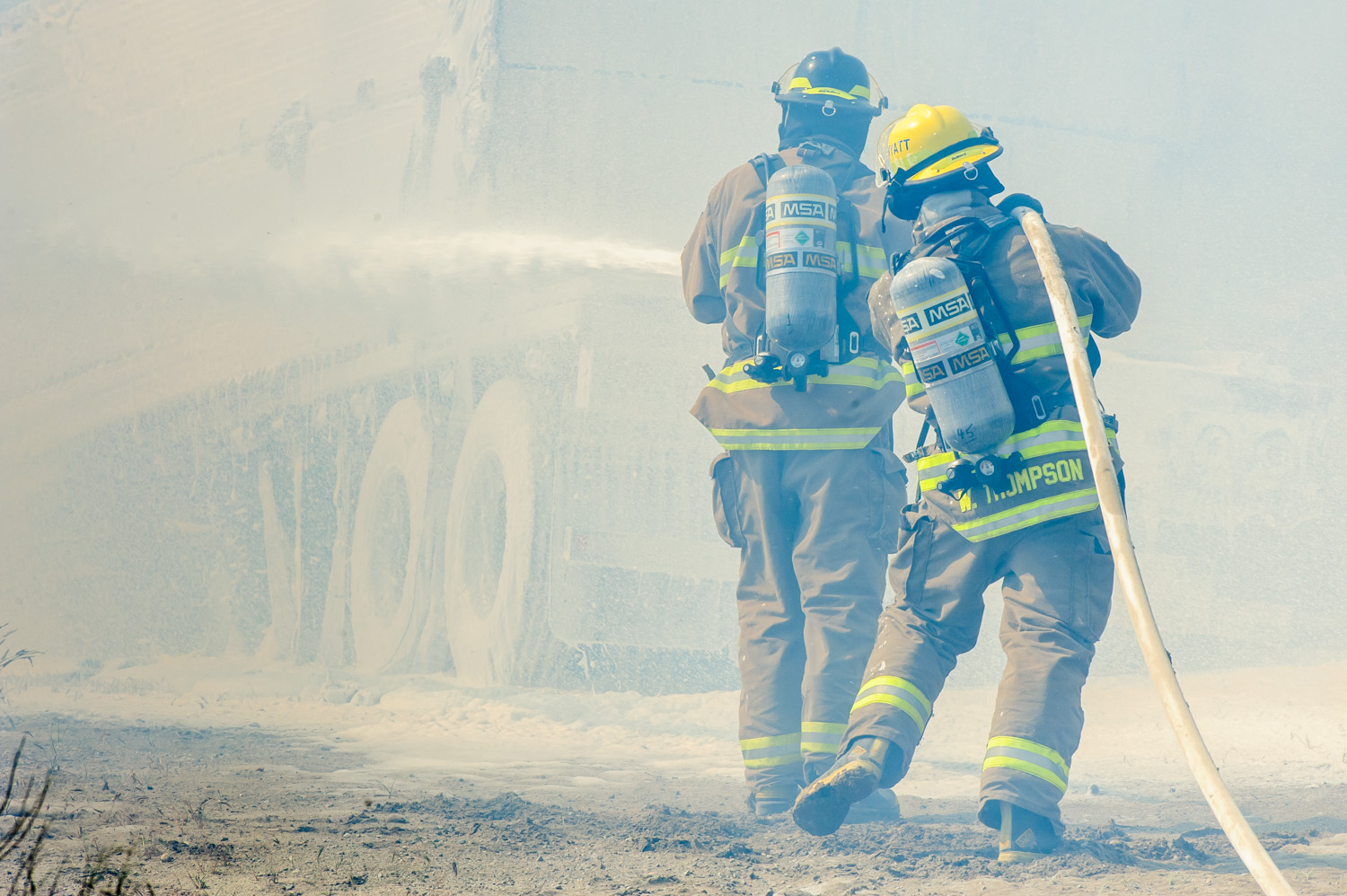 In sweltering heat, Osoyoos firefighters fought to contain a blaze early Wednesday afternoon at Acacia Ct. and Oleander Dr. It appeared the fire gutted a shed, and firefighters were busy spraying the nearby house with foam to prevent the fire from spreading. (Richard McGuire photo)