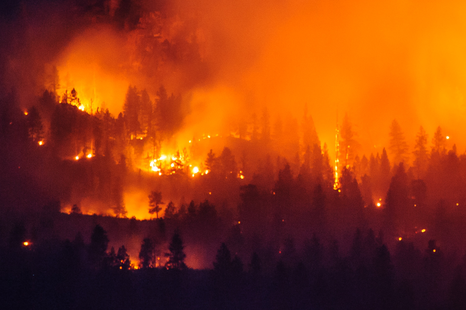 Fires burning east of Osoyoos Lake in a controlled burn make an eerie glow at night, although only smoke was visible during the day. This image was taken from across Osoyoos Lake using a long lens. (Richard McGuire Photo)