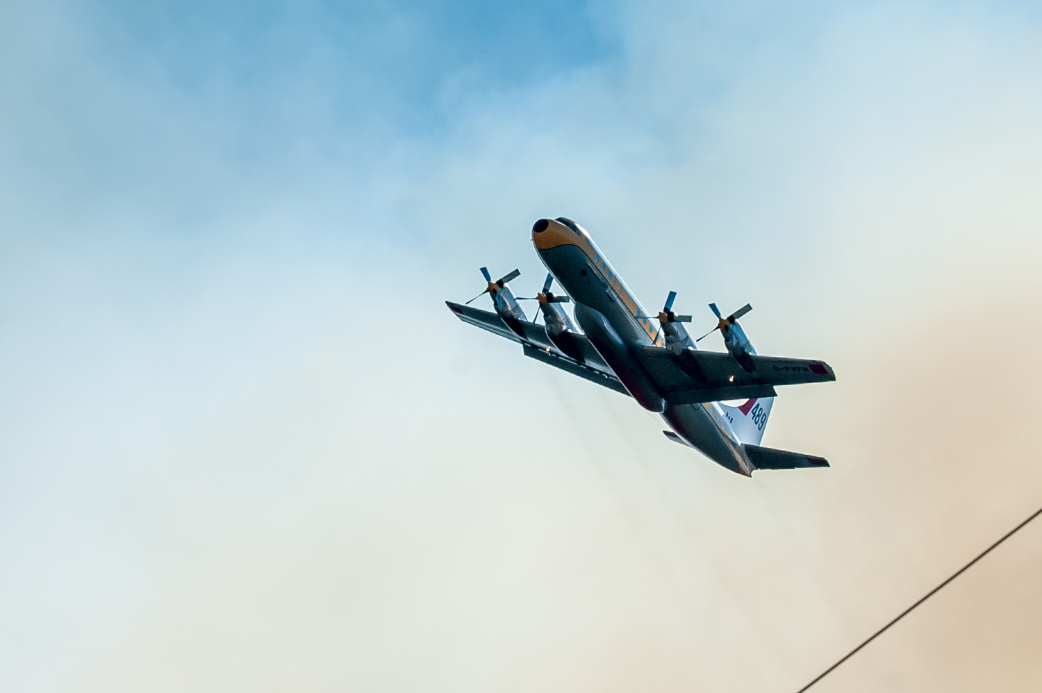 A tanker plane emerges from dense smoke after dropping a load of retardant on a wildfire off Old Richter Pass Road. (Richard McGuire photo)
