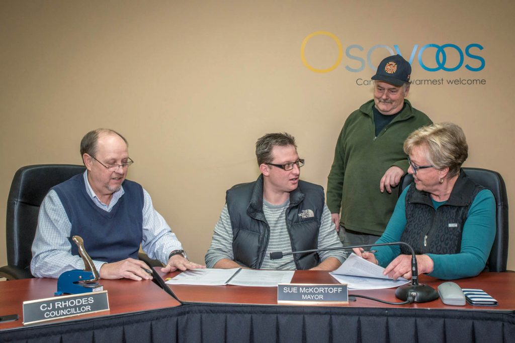 The Town of Osoyoos sign the agreement for construction of the new fire hall on Monday. Seated from left are Barry Romanko, town CAO; Matt Kenyon, general manager of Greyback Construction; and Sue McKortoff, Osoyoos mayor. Standing is Rick Jones, fire chief. (Richard McGuire photo)