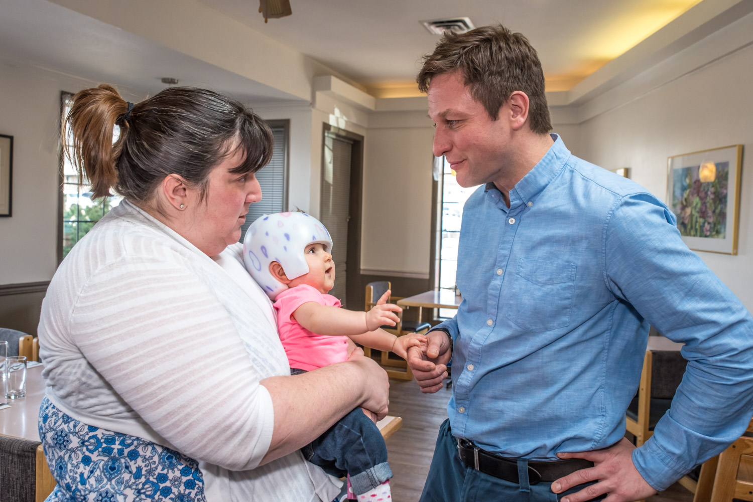 NDP Education Critic Rob Fleming chats with Cheryl Smith, wife of Troy Bratton, owner of Troy's Grill. Scarlett Bratton, not quite 8 months, wants to join in the conversation. Troy's Grill hosted an informal event Tuesday to discuss the school closure issue. Fleming was in Osoyoos to attend Tuesday night's public consultation meeting on the closure of Osoyoos schools. Smith hopes Scarlett will be able to go to OSS in the future. (Richard McGuire photo)