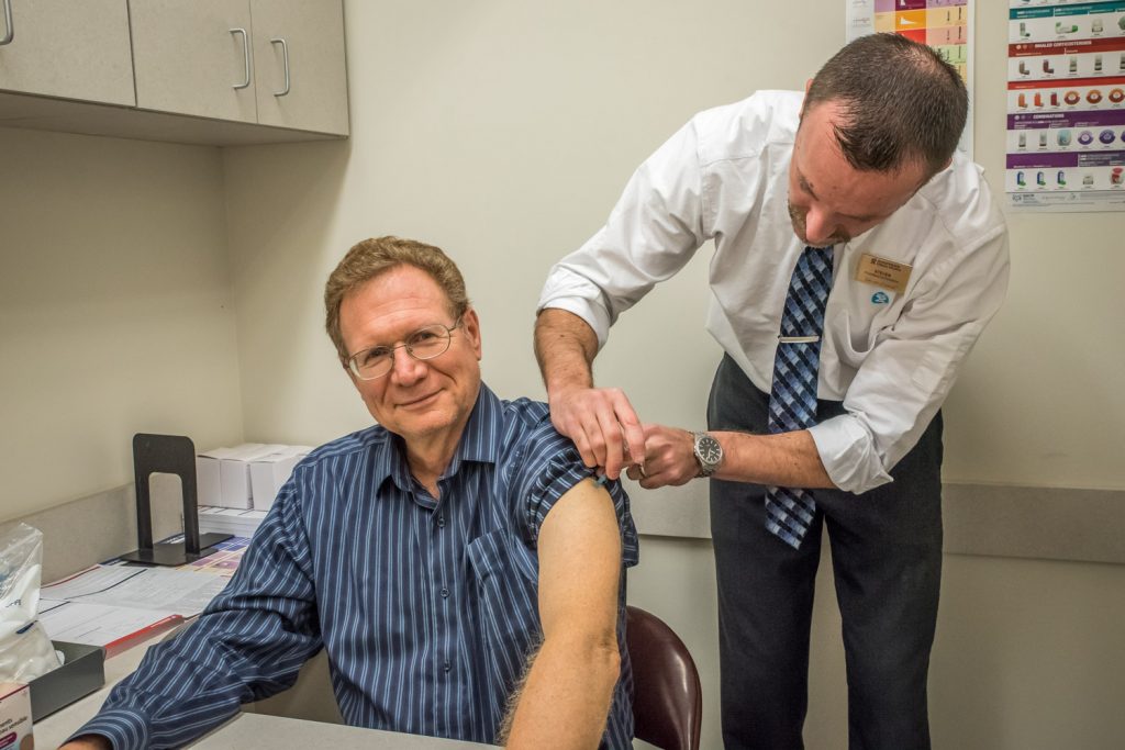 Richard McGuire, reporter/photographer with the Osoyoos Times, gets his annual flu shot from Steven Hopp, owner and pharmacist at Shoppers Drug Mart. Both McGuire and Hopp get the flu vaccination every year. (Keith Lacey photo)