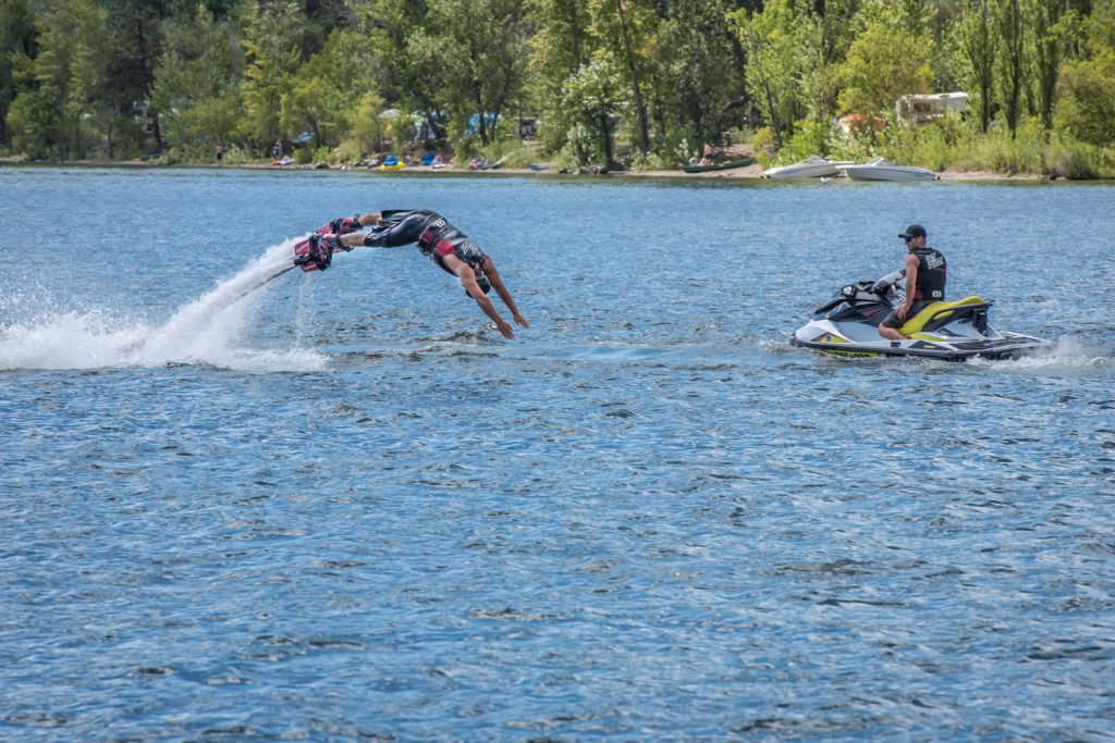 Travis Blacklin dives through the air, propelled by a jet of water, as Paul Reid operates a watercraft in the exciting sport of flyboarding. (Richard McGuire photo)