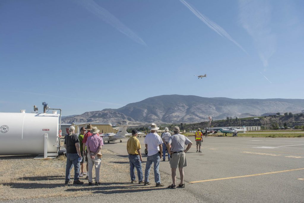 A crowd of flying enthusiasts watch as a pilot takes off from the airstrip at the Oliver Municipal Airport during the Fly-in Breakfast on Aug. 20.