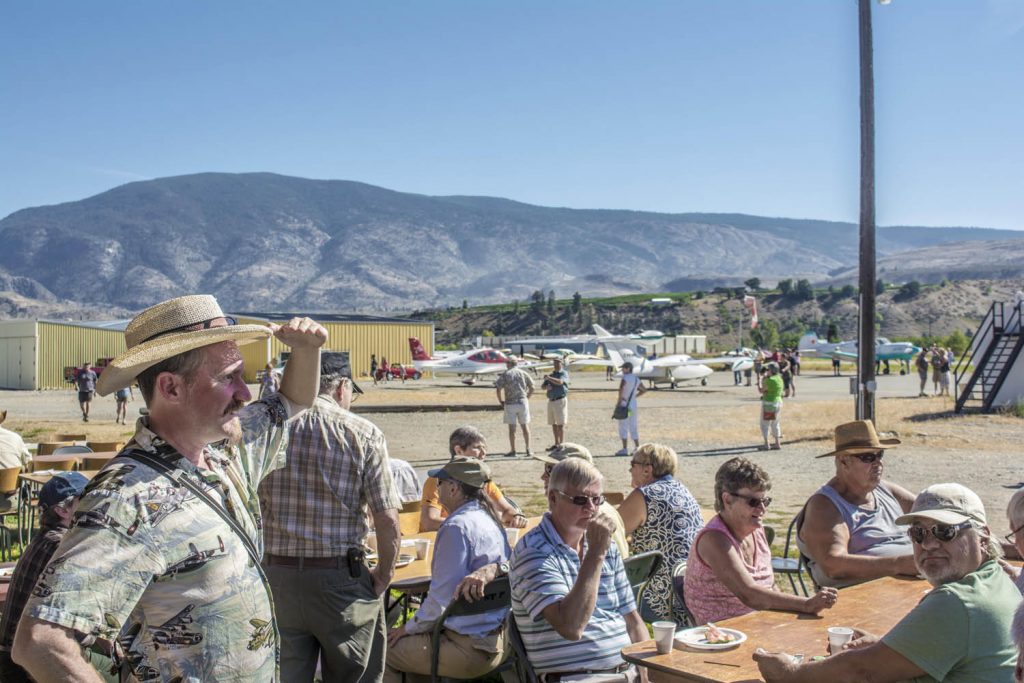Sean Smith (standing with hat) comes nearly every year from Vancouver to enjoy the food at the annual Fly-in Breakfast at the Oliver Municipal Airport. (Dan Walton photo)