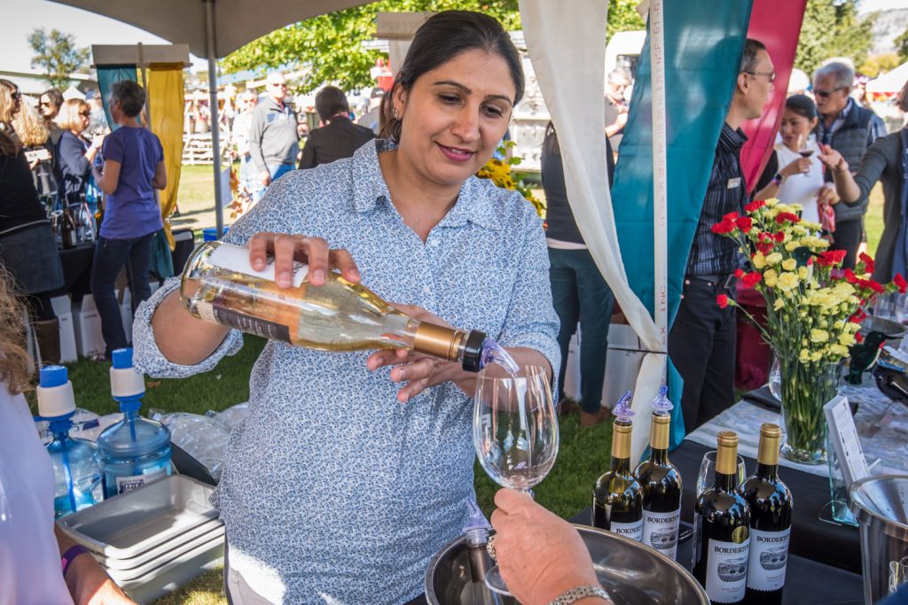 Charangit Gill, one of the owners of Bordertown Winery and Vineyard, pours a glass of white wine for a guest. Part of the attraction of Festival of the Grape is the chance to try excellent wines from throughout the South Okanagan. (Richard McGuire photo)