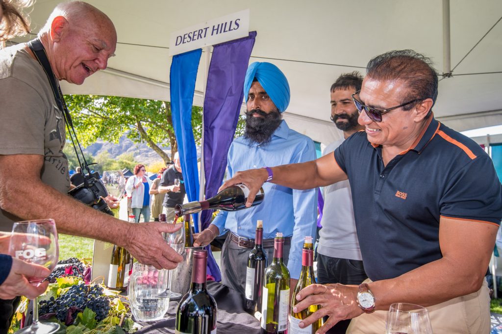 Jesse Tour, of Desert Hills Estate Winery, pours a glass of red wine for a guest at Festival of the Grape. Part of the attraction of this event is the chance to taste excellent wines from throughout the South Okanagan. (Richard McGuire photo)